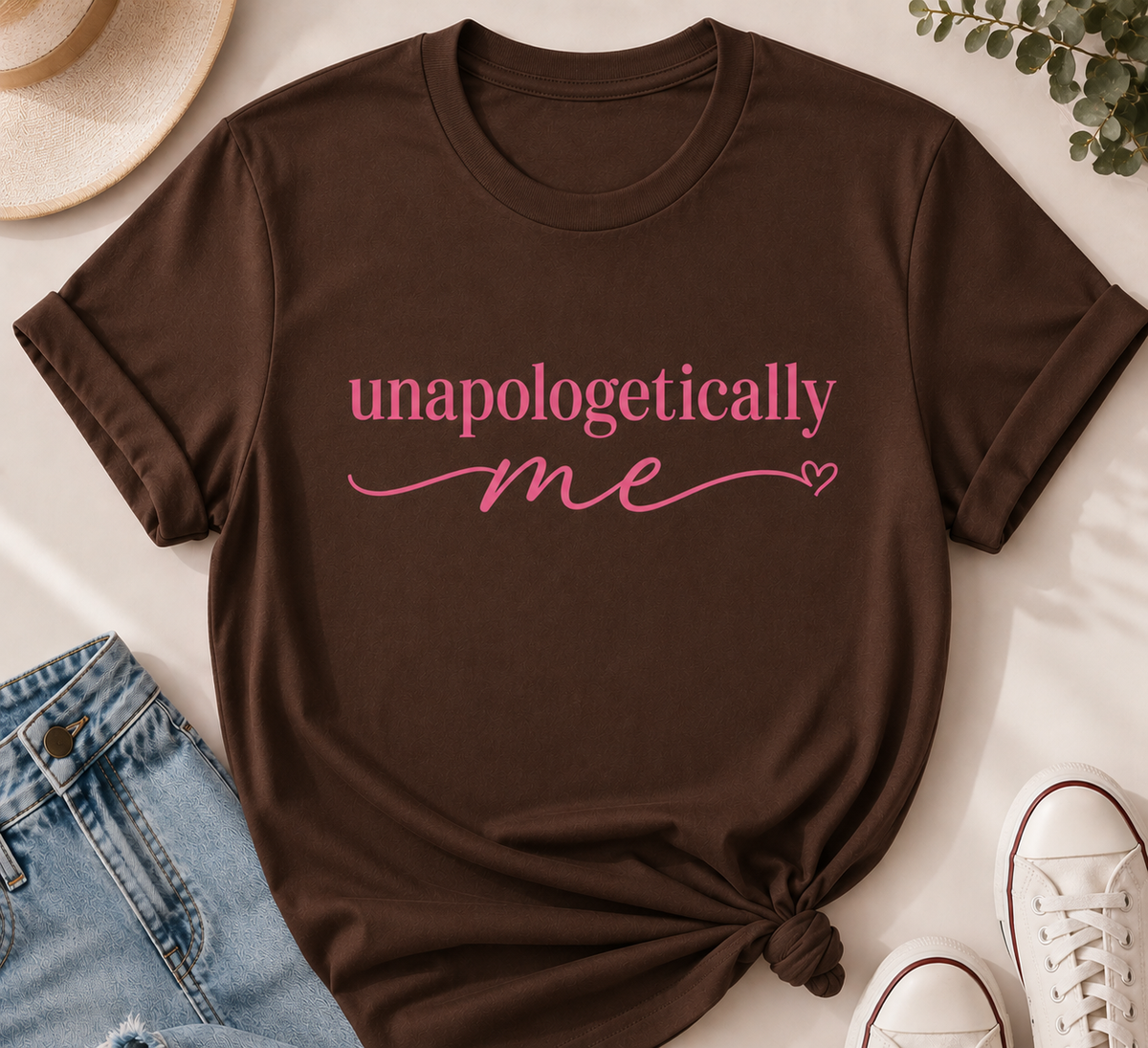 Brown t-shirt with 'unapologetically me' text in pink on a light surface