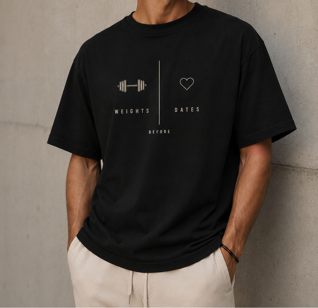 Man wearing a black t-shirt with a graphic design against a concrete wall.