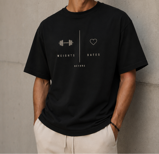 Man wearing a black t-shirt with a graphic design against a concrete wall.